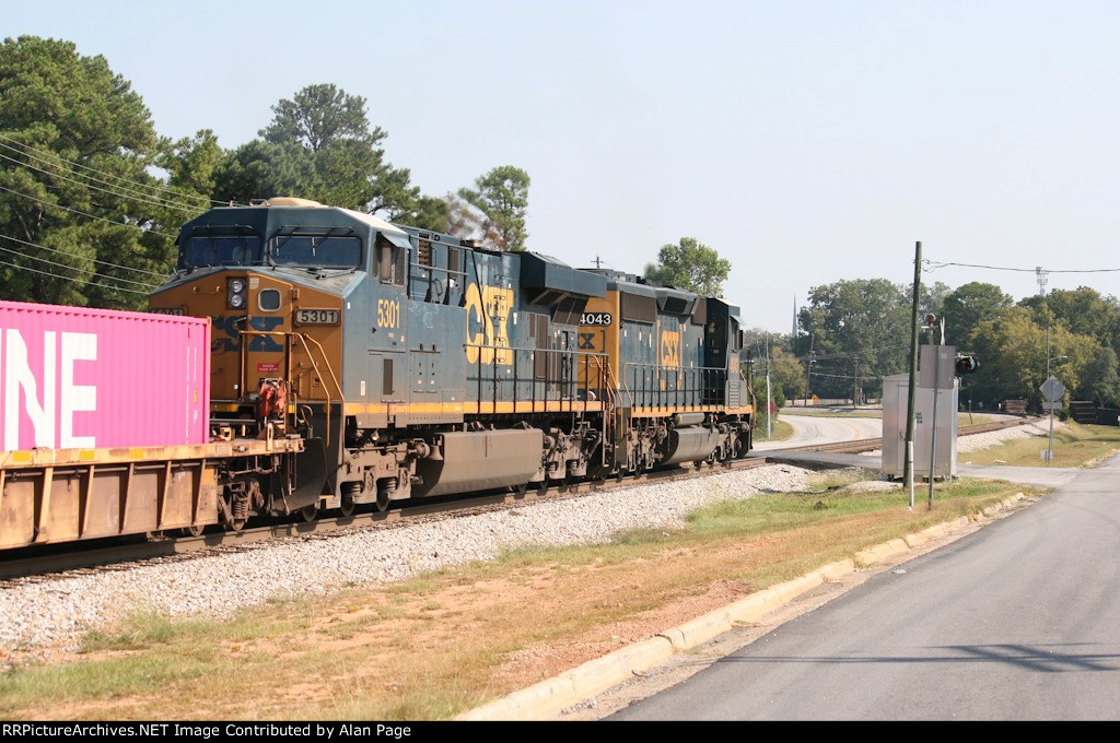 CSX 4043 leads 5301 and a line of containers
